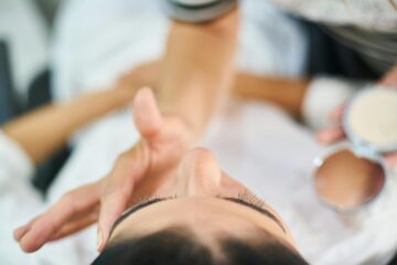 Close-up view of a professional makeup artist applying cosmetics indoors, highlighting beauty and skin care.