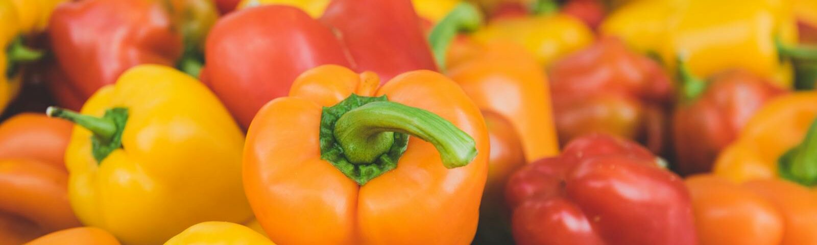 Colorful assortment of fresh, ripe bell peppers in close-up, highlighting food freshness.