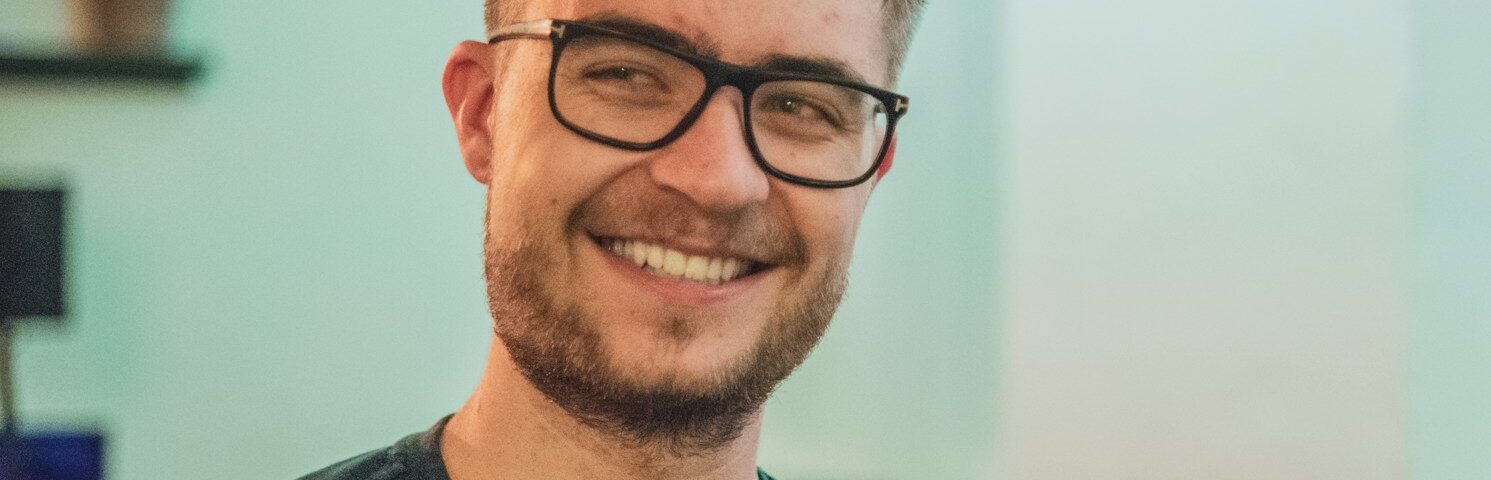 man wearing green crew-neck top and eyeglasses with black frames looking at side